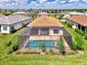 Aerial view of a private screened-in pool surrounded by lush greenery in a tranquil backyard setting at 6267 Crested Eagle Ln, Nokomis, FL 34275