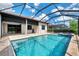 Inviting screened-in pool and spa area with a blue-tile and travertine patio, perfect for relaxation and outdoor enjoyment at 6267 Crested Eagle Ln, Nokomis, FL 34275