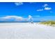 White sandy beach with clear blue sky and tranquil ocean waters at 6267 Midnight Pass Rd # 306, Sarasota, FL 34242