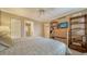 Cozy bedroom with a small closet and bookshelf, view of the bathroom, and a comfortable queen bed at 6267 Midnight Pass Rd # 306, Sarasota, FL 34242