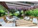 Comfortable deck space with white lounge chairs and pergola, perfect for relaxing in a lush, verdant setting at 6267 Midnight Pass Rd # 306, Sarasota, FL 34242