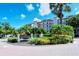 Attractive entrance sign to Excelsior condos featuring lovely landscaping, a fountain, and brick-paved roundabout at 6267 Midnight Pass Rd # 306, Sarasota, FL 34242