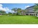 Manicured lawn with small water feature in front of a multi-story condo building at 6267 Midnight Pass Rd # 306, Sarasota, FL 34242