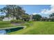 Beautiful condo exterior showing the building with well-manicured landscaping, a pond, and mature trees at 6267 Midnight Pass Rd # 306, Sarasota, FL 34242