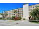 Attractive condo building with tropical landscaping, lush plantings, and visible parking at 6267 Midnight Pass Rd # 306, Sarasota, FL 34242