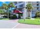 Exterior of the building with a red awning over the entrance to the office, as well as lush landscaping at 6267 Midnight Pass Rd # 306, Sarasota, FL 34242