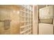 Glass block shower with tan tile surround, and stacked washer and dryer unit, perfect for convenience at 6267 Midnight Pass Rd # 306, Sarasota, FL 34242