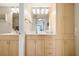 Bathroom with light wood cabinets and a mirror reflecting a view of the ocean at 6480 Midnight Pass Rd # 315, Sarasota, FL 34242