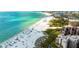 Aerial view of a beautiful beach with turquoise water, white sand, and people enjoying the sun at 6480 Midnight Pass Rd # 315, Sarasota, FL 34242