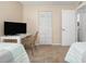 Well-lit bedroom showcasing a desk, television, closet, and a view into the en-suite bathroom at 6480 Midnight Pass Rd # 315, Sarasota, FL 34242