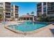 Large, inviting community pool with lounge chairs, set amongst lush landscaping and condo buildings at 6480 Midnight Pass Rd # 315, Sarasota, FL 34242