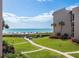 Exterior shot showcasing condo amenities, green space with a path to the beach and blue skies at 6480 Midnight Pass Rd # 315, Sarasota, FL 34242