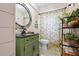 Charming bathroom featuring a green vanity, floral shower curtain, and stylish decor at 6604 23Rd W Ave, Bradenton, FL 34209