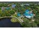 Aerial view of the community center, featuring the clubhouse, pool, tennis courts, and golf course at 7016 Lennox Pl, University Park, FL 34201