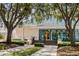 Charming building entrance with a blue tile roof, framed by mature trees and landscaping at 7016 Lennox Pl, University Park, FL 34201