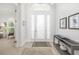 Bright foyer with a modern console table, neutral decor, tile floors, and a clear view to adjacent room at 7016 Lennox Pl, University Park, FL 34201