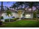 Charming single-story home showcasing lush landscaping, an arched entryway, and a welcoming two-car garage at 7016 Lennox Pl, University Park, FL 34201