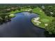 Picturesque aerial view of the golf course featuring a serene lake, lush green fairways, and challenging sand traps at 7016 Lennox Pl, University Park, FL 34201