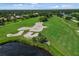 Scenic aerial view of the meticulously landscaped golf course showcasing lush green fairways, water features, and mature trees at 7016 Lennox Pl, University Park, FL 34201