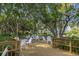 Charming outdoor patio with elegant seating, shaded by mature trees, providing a perfect spot for relaxation at 7016 Lennox Pl, University Park, FL 34201