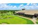 Aerial view of a golf course clubhouse and landscaped grounds with a golf cart at 7158 Westhill Ct, Lakewood Ranch, FL 34202