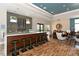 Bar area with seating and lovely decor, including tile backsplash and wood floors at 7158 Westhill Ct, Lakewood Ranch, FL 34202