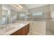 This updated bathroom features a double vanity, a glass enclosed shower with a bench, and tile throughout at 7158 Westhill Ct, Lakewood Ranch, FL 34202