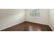 Bedroom featuring hardwood floors, white walls, and window with plantation shutters at 7158 Westhill Ct, Lakewood Ranch, FL 34202
