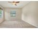 The light-filled bedroom boasts neutral walls and carpeting with a window overlooking a lush landscape at 7158 Westhill Ct, Lakewood Ranch, FL 34202