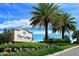 Entrance to a beautiful community with lush landscaping and swaying palms under blue skies at 7158 Westhill Ct, Lakewood Ranch, FL 34202