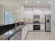 Modern kitchen with white cabinetry, stainless steel appliances, and granite countertops for a sleek and stylish design at 7158 Westhill Ct, Lakewood Ranch, FL 34202