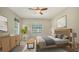 This staged main bedroom has neutral tones, modern fixtures, and a window overlooking a lush landscape at 7158 Westhill Ct, Lakewood Ranch, FL 34202