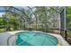 The screened-in lanai features an in-ground pool with a waterfall feature and lush landscaping at 7158 Westhill Ct, Lakewood Ranch, FL 34202
