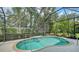 Private screened-in pool surrounded by lush greenery and a stone deck for relaxing at 7158 Westhill Ct, Lakewood Ranch, FL 34202