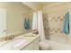 Cozy bathroom featuring a shower with curtain, integrated sink and vanity, and tiled walls at 7576 Plantation Cir, Bradenton, FL 34201