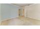 Spacious bedroom with neutral carpet, light blue wall, and an open doorway to an adjacent room at 7576 Plantation Cir, Bradenton, FL 34201