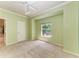 Bright bedroom with a ceiling fan and large window overlooking an outside view, carpeted floor at 7576 Plantation Cir, Bradenton, FL 34201