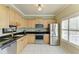 Well-lit kitchen featuring stainless steel appliances, light wood cabinetry, and black granite countertops at 7576 Plantation Cir, Bradenton, FL 34201