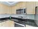 This kitchen features light wood cabinets, stainless steel appliances, and black granite countertops at 7576 Plantation Cir, Bradenton, FL 34201