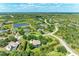 An aerial view of a community with lakes, winding roads, and houses nestled among trees at 8136 Snowy Egret Pl, Bradenton, FL 34202