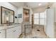 Well-lit bathroom featuring granite countertops, tiled floors, and a glass shower at 8136 Snowy Egret Pl, Bradenton, FL 34202