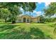 Inviting single-story home featuring a lush lawn, mature trees, and charming curb appeal under a blue sky at 8136 Snowy Egret Pl, Bradenton, FL 34202