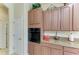 Kitchen highlights wood cabinets, built in oven, granite countertops and easy access door to hall at 8136 Snowy Egret Pl, Bradenton, FL 34202