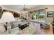 Sunlit living room with patio doors leading to pool, comfortable seating, and floral rug at 8136 Snowy Egret Pl, Bradenton, FL 34202