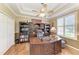 Elegant office with a wooden desk, built-in bookcases, plantation shutters, and a tray ceiling at 8136 Snowy Egret Pl, Bradenton, FL 34202
