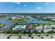 Gorgeous aerial view of the community clubhouse with pool, tennis court, parking and lake views at 8936 Artisan Way, Sarasota, FL 34240