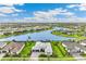 Beautiful aerial view of a modern home overlooking a serene lake in a vibrant, planned community at 8936 Artisan Way, Sarasota, FL 34240