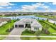 A stunning aerial view shows a well-manicured property with three-car garage situated on a waterfront lot at 8936 Artisan Way, Sarasota, FL 34240