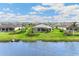 Expansive backyard view showcasing lush greenery and a private screened in lanai by the lake at 8936 Artisan Way, Sarasota, FL 34240