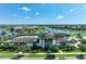 Beautiful community clubhouse featuring palm trees, lush landscaping, and views of the lake at 8936 Artisan Way, Sarasota, FL 34240